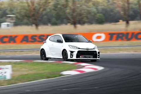 A white hatchback through a bend over red and white kerbs