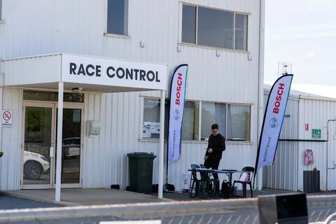 The Race Control building with Bosch flags and a person standing outside